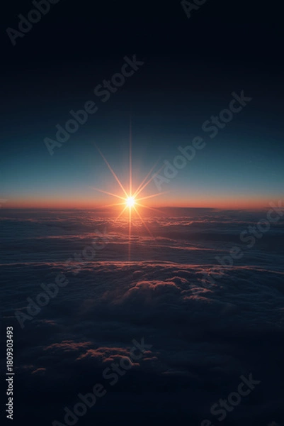 Fototapeta Golden-hour sunrise above sculpted atmospheric cloud layers, warm inner glow contrasting with cool blue shadows, intense central starburst flare