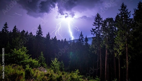 Fototapeta Intense lightning bolts illuminate a dark, forested mountain landscape under ominous storm clouds in a dramatic scene