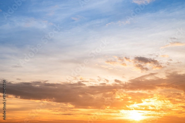 Fototapeta Sunset or sunrise sky with a vibrant gradient of orange, gold, and soft blue. Clear atmosphere with wispy clouds. Peaceful, natural light background. hope, freedom, new day and inspirational Concepts