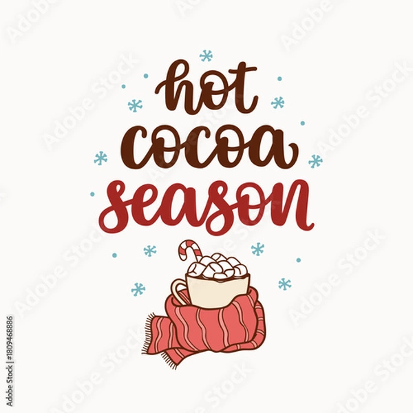 Fototapeta Hot cocoa season hand lettering and a cup of cocoa with marshmallows, wrapped in a scarf. Hygge and winter vibes concept