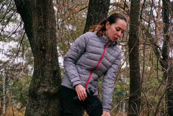 Fototapeta A young woman is resting after a run in the forest. Breathing after exercise