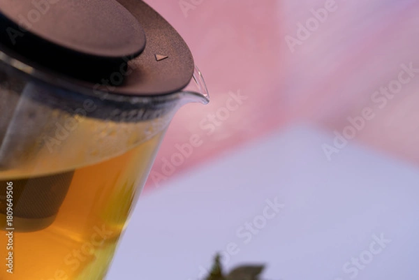 Fototapeta Close view of teapot lid and spout with beads of condensation; selective focus and a pastel backdrop frame brewing details for natural tea branding, product design and warm lifestyle.