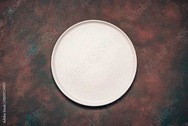 Fototapeta Empty beige plate on dark grunge rusty background, top view, flat lay, copy space.