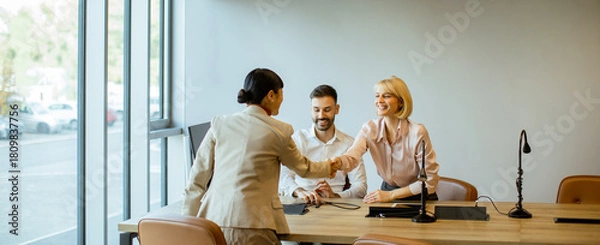 Fototapeta Business meeting with handshake between colleagues in a modern office