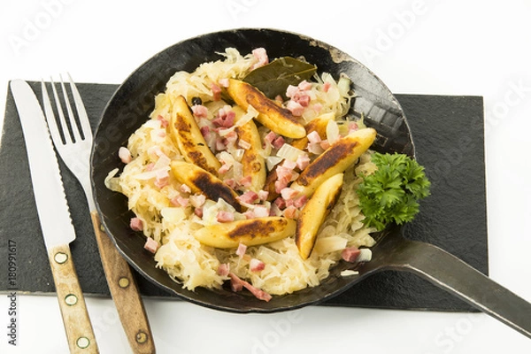 Fototapeta Schupfnudeln mit Kraut und Speck in gußeisener Pfanne, Freisteller