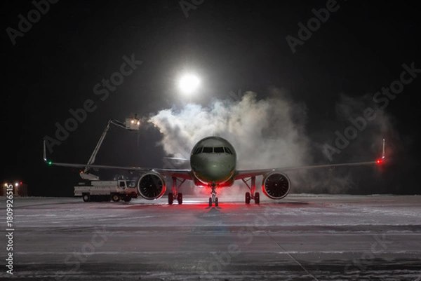 Obraz Ground deicing of a passenger jetliner on the night airport at winter