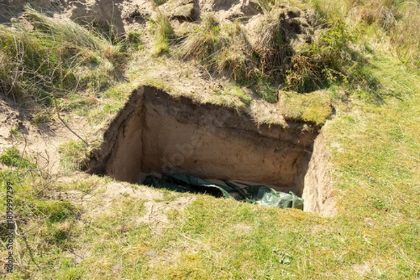 Obraz Neat rectangular hole in the ground in the sand dunes, at Formby, Merseyside, England,UK. It's not a grave but it looks very like one.