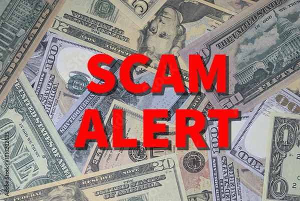 Fototapeta Background of US currency overlaid with words SCAM ALERT in red