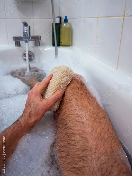 Fototapeta Washing foot with sponge in relaxing bath
