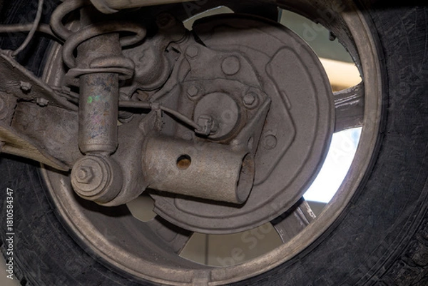 Fototapeta Wear on coil spring shock absorber and twisted axle beam indicates high mileage or rough road use. selective focus