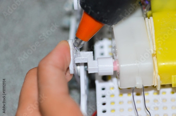 Obraz Men are using hot glue to the device.