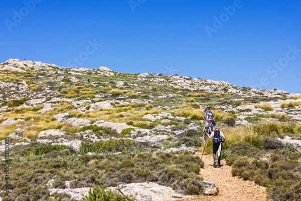Obraz Hikers on the way up at a mountain trail in a rocky landscape at a mountain