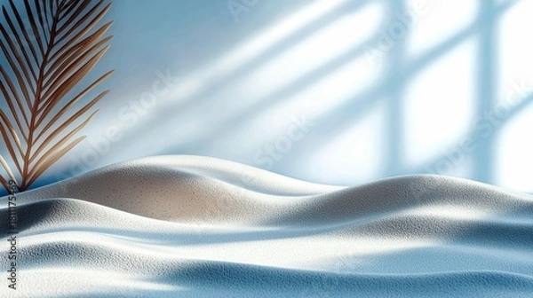 Fototapeta A serene scene of soft, textured sand dunes with gentle curves, illuminated by sunlight casting a patterned shadow on a pale blue background, with a single drie