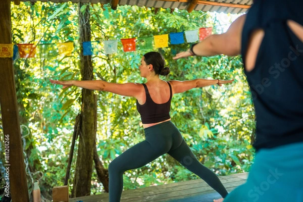 Obraz Woman practicing warrior pose during yoga session
