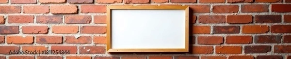 Fototapeta Blank wooden frame hangs on weathered brick Ideal for showcasing design , wooden frame, aged