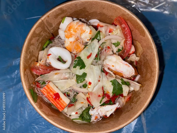 Obraz Thai seafood glass noodle salad in a bowl, featuring prawns, squid, vegetables, and spicy tangy dressing.