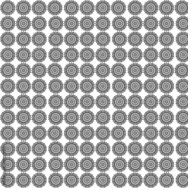 Fototapeta Repeating pattern of intricate floral designs in black and white creating a textured background effect