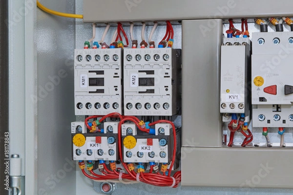 Fototapeta Magnetic starters with thermal relays connected by wires. Starters installed in electric Cabinet. Monitoring relay phase circuit breaker motor protection. Wire laid in the cable channel.