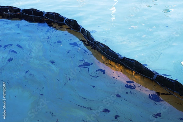 Fototapeta Oil spill. Environmental disaster. A containment boom is a temporary floating barrier used to contain an oil spill.
