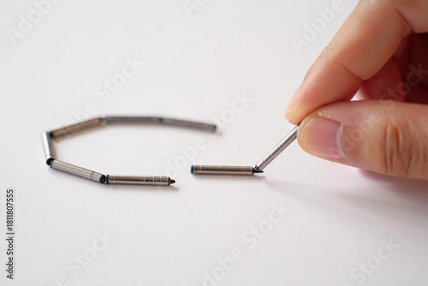 Obraz Hand Connecting Metal Cylinders for Assembly or Chain Link Concept on White Background 150 Characters