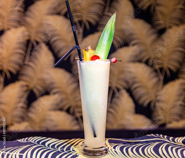 Fototapeta Exotic Piña Colada or Tropical Creamy Cocktail with Pineapple Leaf Garnish
