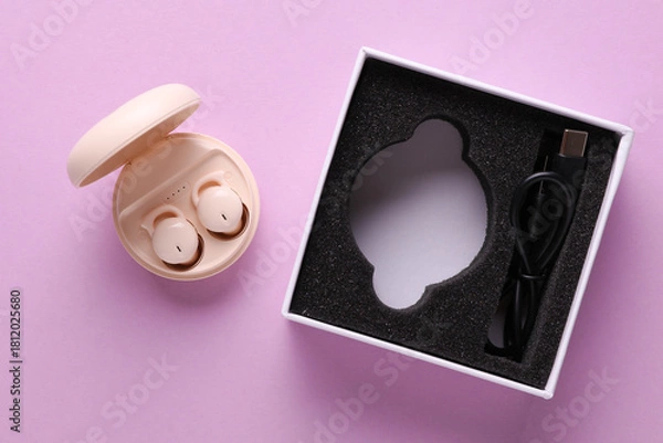 Fototapeta New Modern Wireless Bluetooth Vacuum Earbuds with Charging Case and box on Purple Background