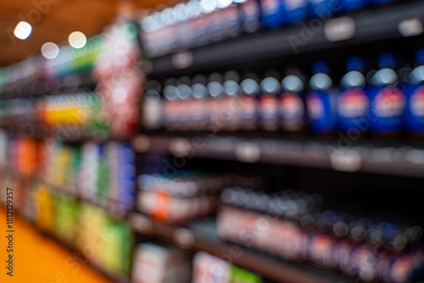 Fototapeta Blurred view of beverage bottles on market shelf.