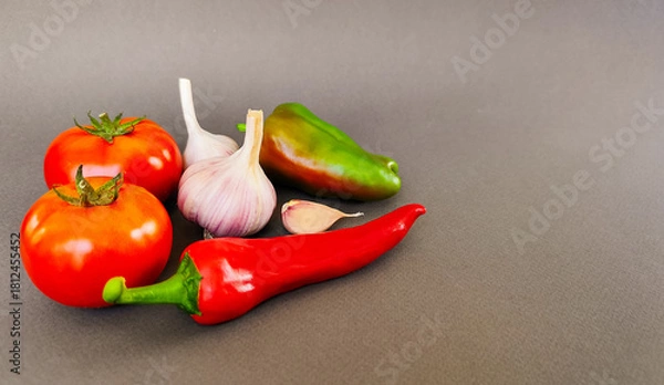 Fototapeta Composition of tomatoes, peppers and garlic on a gray background, top view with space for text