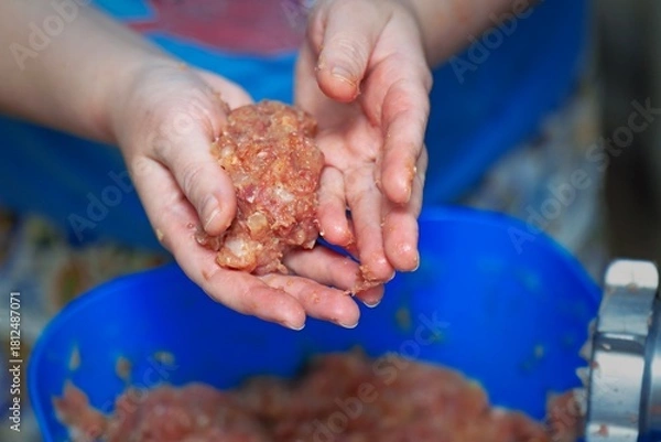 Fototapeta Chef's hands shaping a meat patty from fresh mince in a professional kitchen