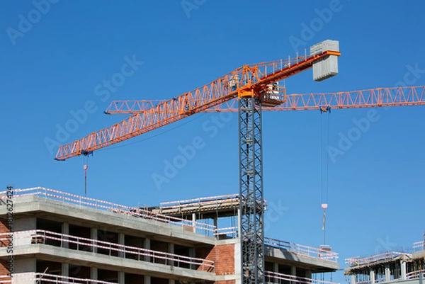 Fototapeta cranes on construction site with blue sky on a background 