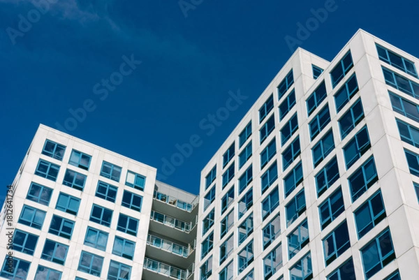 Fototapeta Modern architecture of sleek office buildings against a clear blue sky in an urban setting
