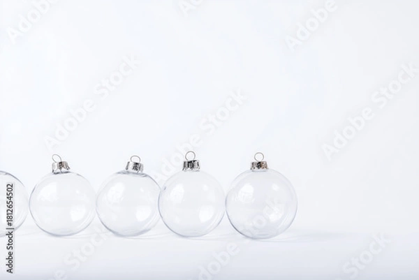 Fototapeta A group of clear glass ornaments are sitting on a white background