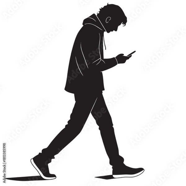Fototapeta Silhouette of a young man in a hoodie walking and using a smartphone.