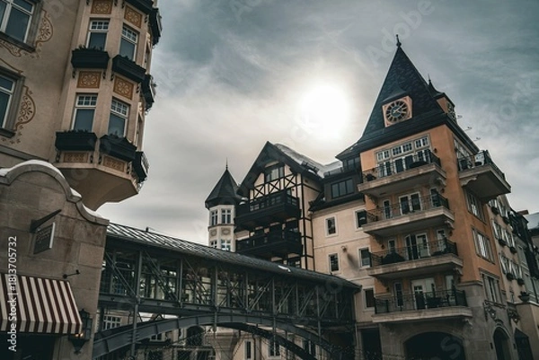 Fototapeta Historic European architecture in a charming old town square under a dramatic cloudy sky showcasing intricate building details and balconies