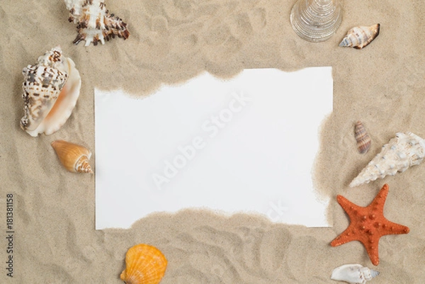 Fototapeta Seashells on sand with white paper in center
