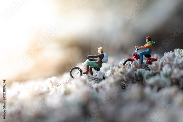 Fototapeta Miniature people riding motorbikes on a blurred background representing travel and adventure