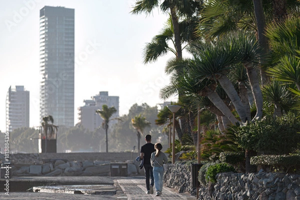 Fototapeta Couple walking on pavement near palm trees in Limassol, Cyprus
