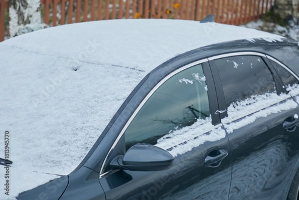 Fototapeta Close-up of car roof and windows covered with snow in winter