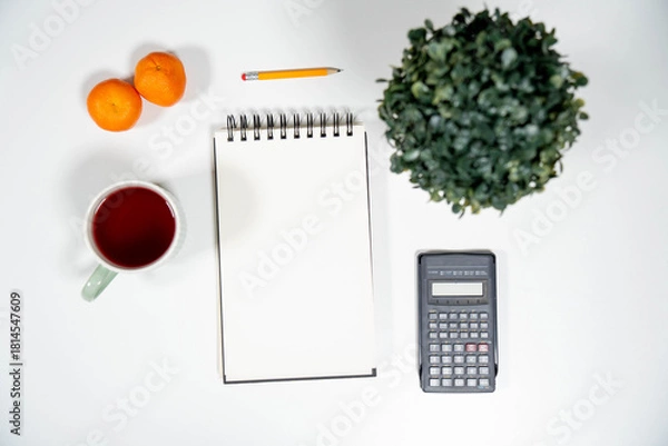 Obraz Flat lay of a blank notepad, calculator, tangerines, and tea. Ideal mockup for financial budgeting, diet planning, or healthy lifestyle resolutions.