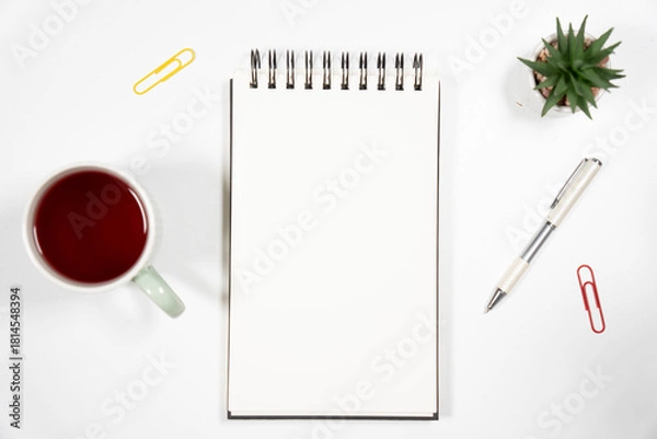Fototapeta Clean office desk flat lay with a blank sketchbook, red tea cup, pen, and succulent. Perfect mockup for business branding, education, or blogging.