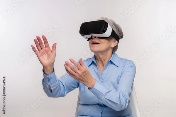 Fototapeta A woman enjoys a virtual reality experience while sitting indoors, demonstrating the technology to seniors. Generative AI