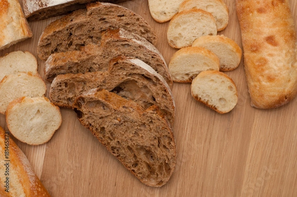 Fototapeta Bread chopped on wooden board with space for text