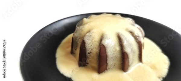 Fototapeta Chocolate Pudding with Creamy Vanilla Sauce  Custard on Black Plate Isolated on White Background. Food Stylish Photography