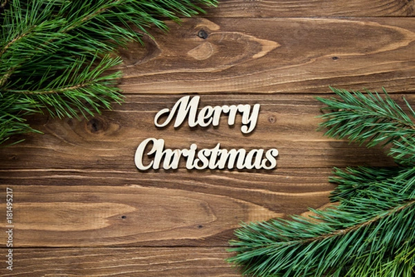 Fototapeta Christmas decoration. Pine tree branch in the corners of the wooden table. Merry Christmas