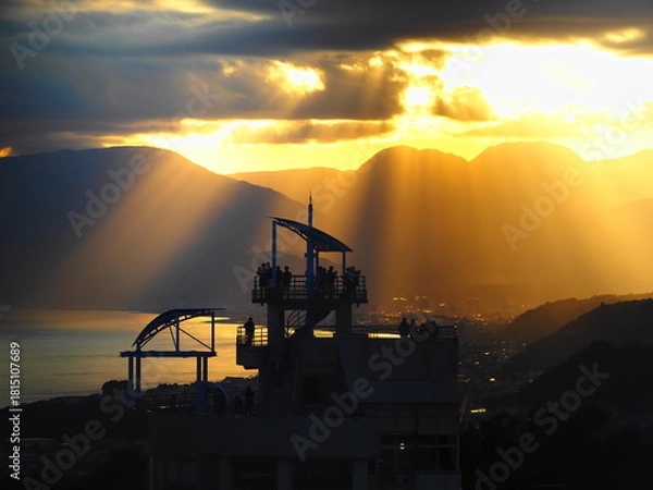 Obraz 展望台で夕日を見る人々