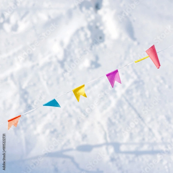 Fototapeta Colorful flags strung across a snowy landscape for festive decoration and celebration