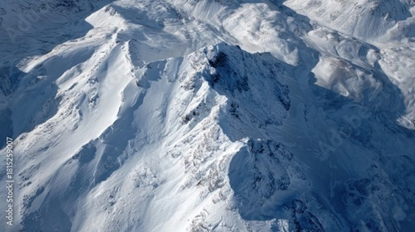 Obraz Snow-Covered Mountain Peaks Under Clear Blue Sky in Majestic Winter Landscape with Dramatic Shadows and Highlights