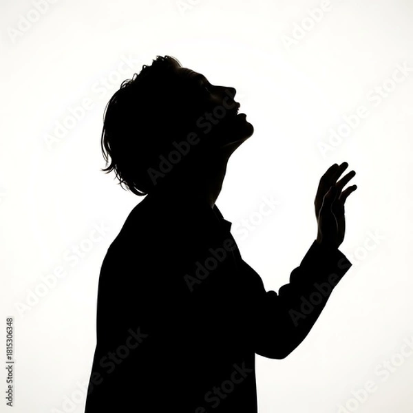 Obraz Silhouette of a person looking up with an open hand gesture against a bright white background.