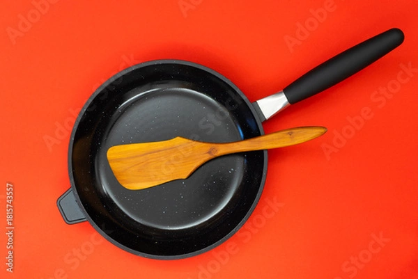 Obraz Frying pan with wooden kitchen and copyspace on red background