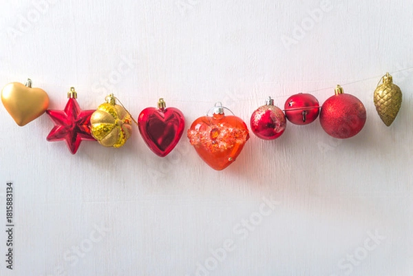Obraz Red and golden christmas decorations hanging on a white background; copy space